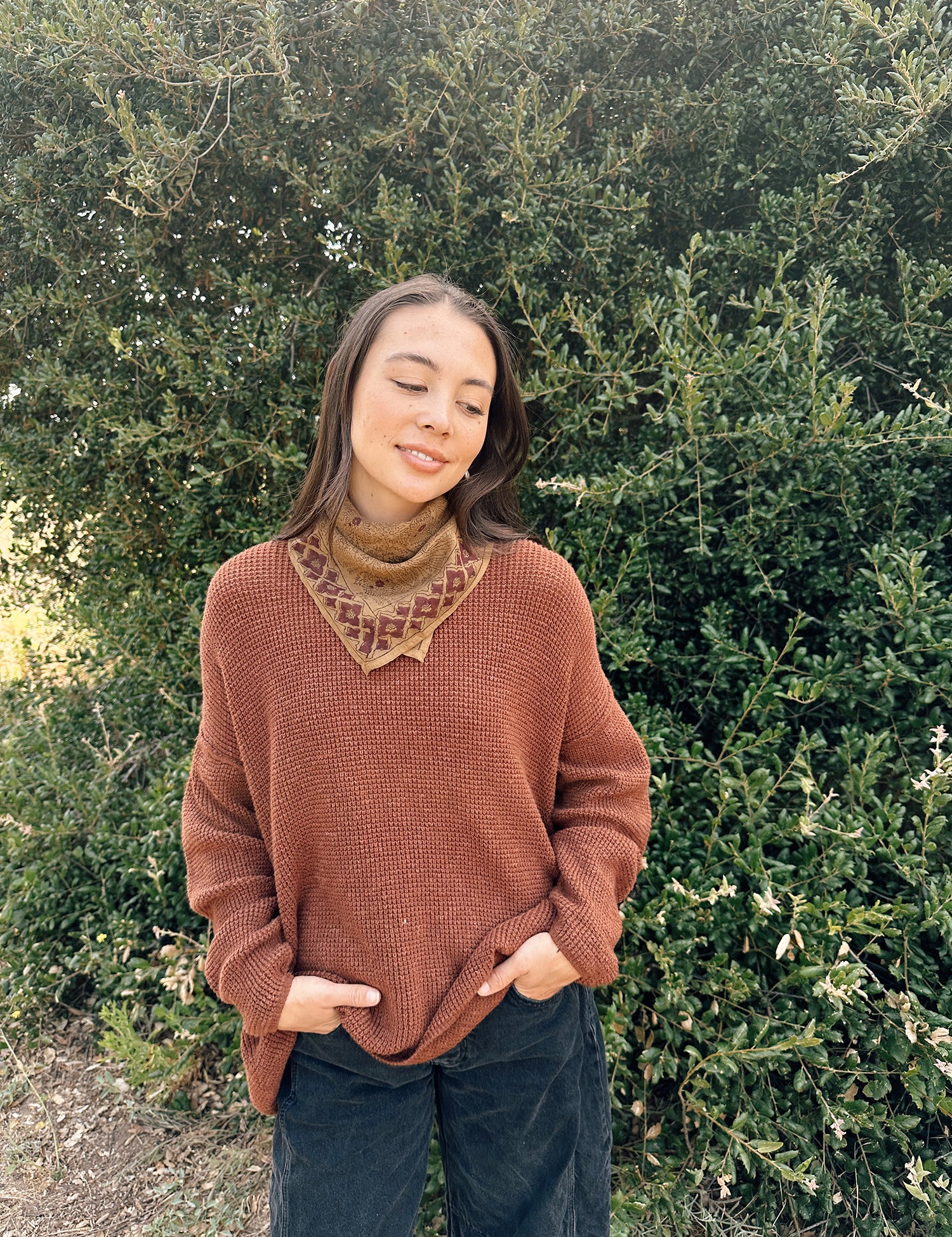Floral printed bandana tied around the neck, styled with an orange brown sweater