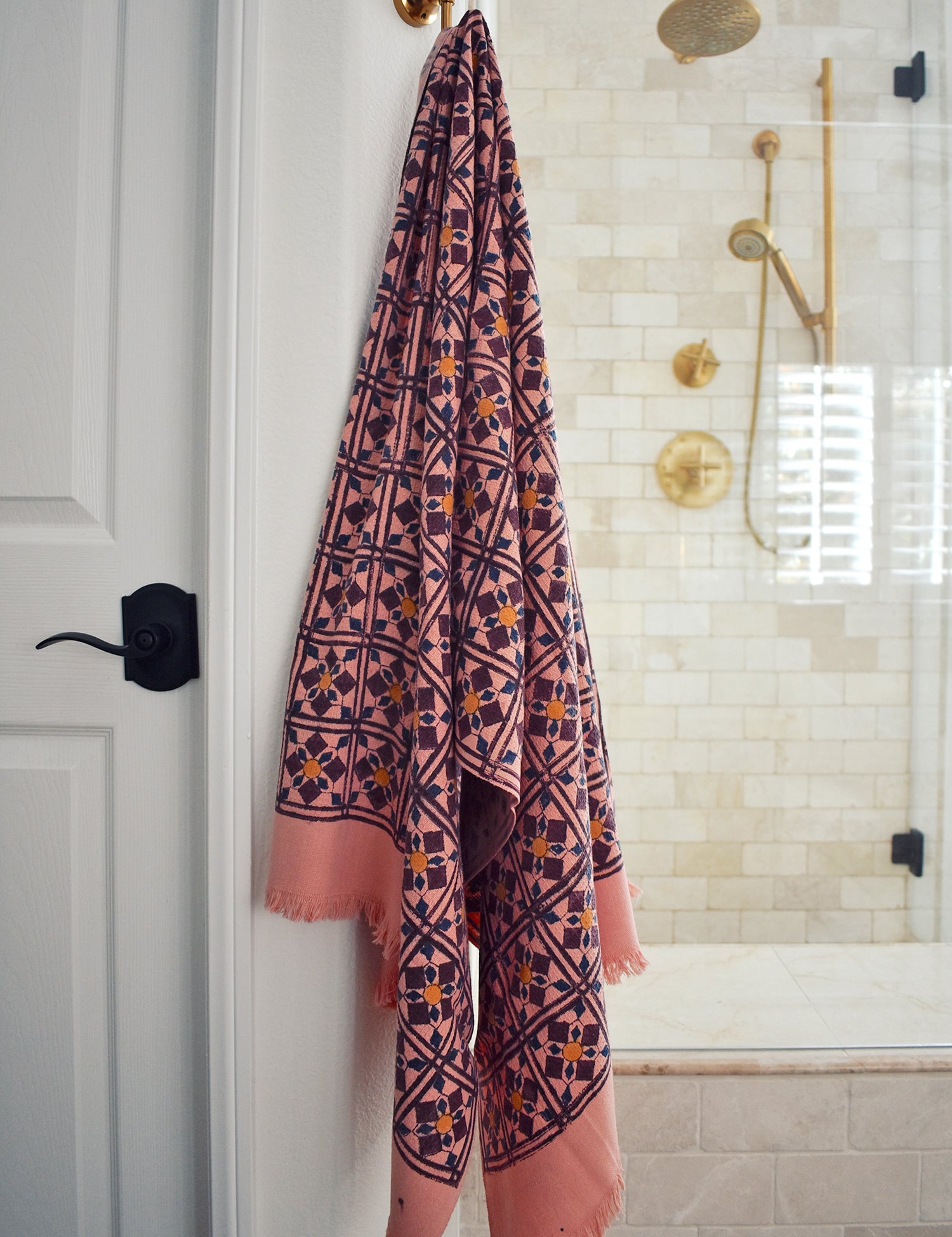 Block printed diamond design waffle weave bath towel hanging on a hook