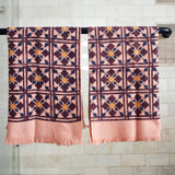 Block printed geometric diamond printed waffle weave khadi hand towels hanging on a shower rod
