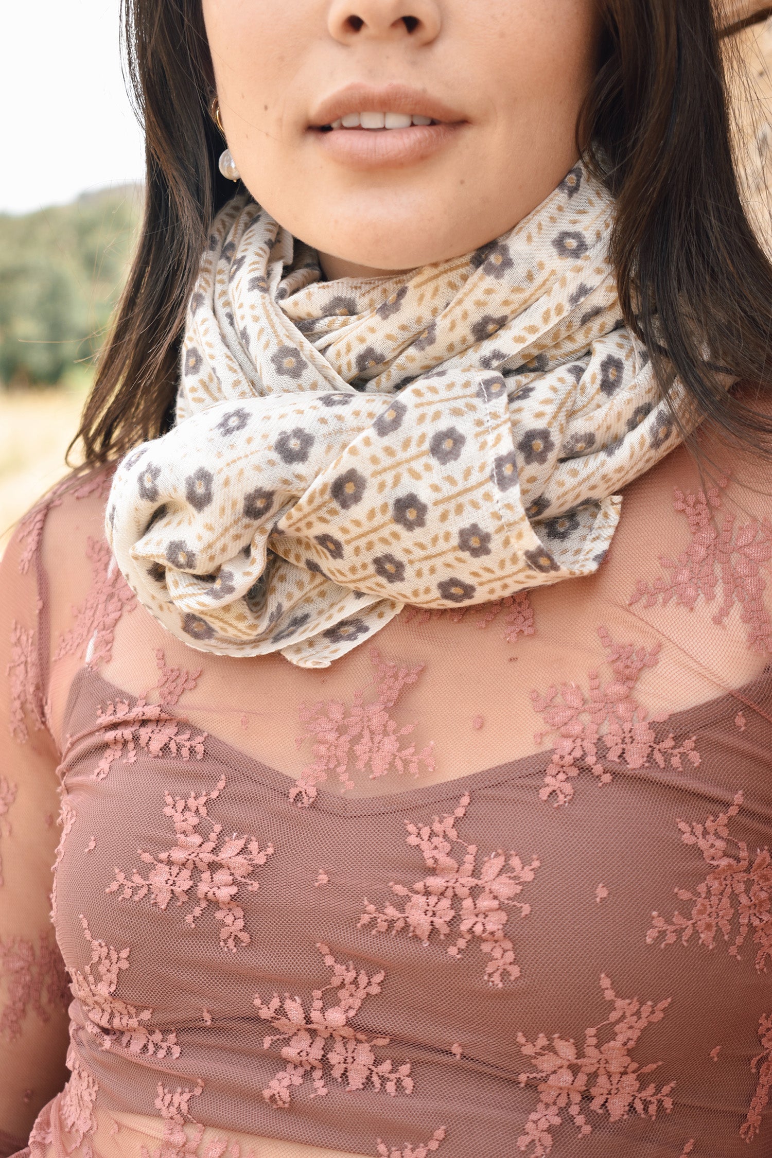 Block printed floral printed chunky wool scarf looped around the neck, worn with sheer rose long sleeve