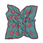 Block printed Monstera bandana, laid flat and scrunched up. Bandana has a red leaf print.