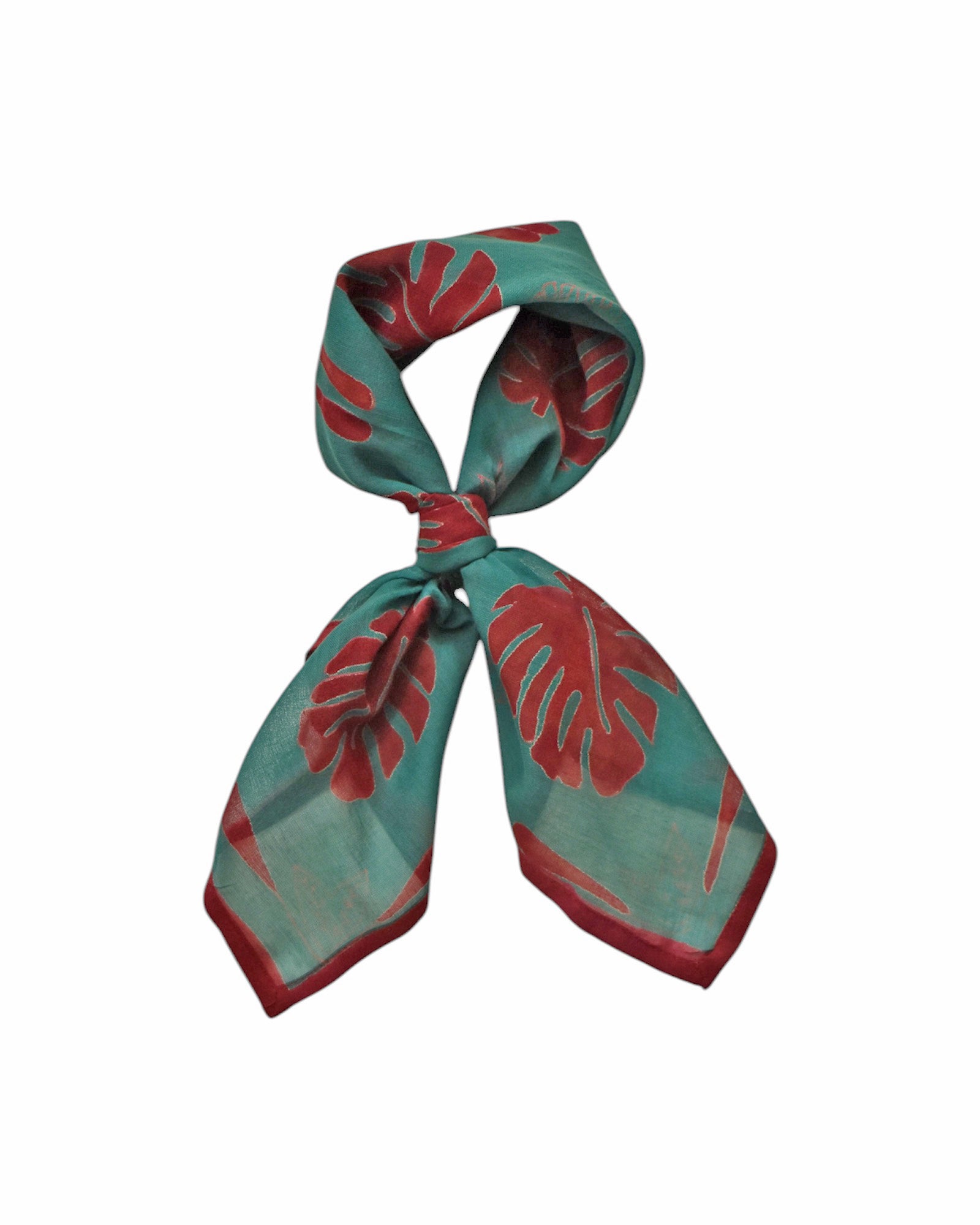 Block printed Monstera bandana, tied up. Bandana has a red leaf print.