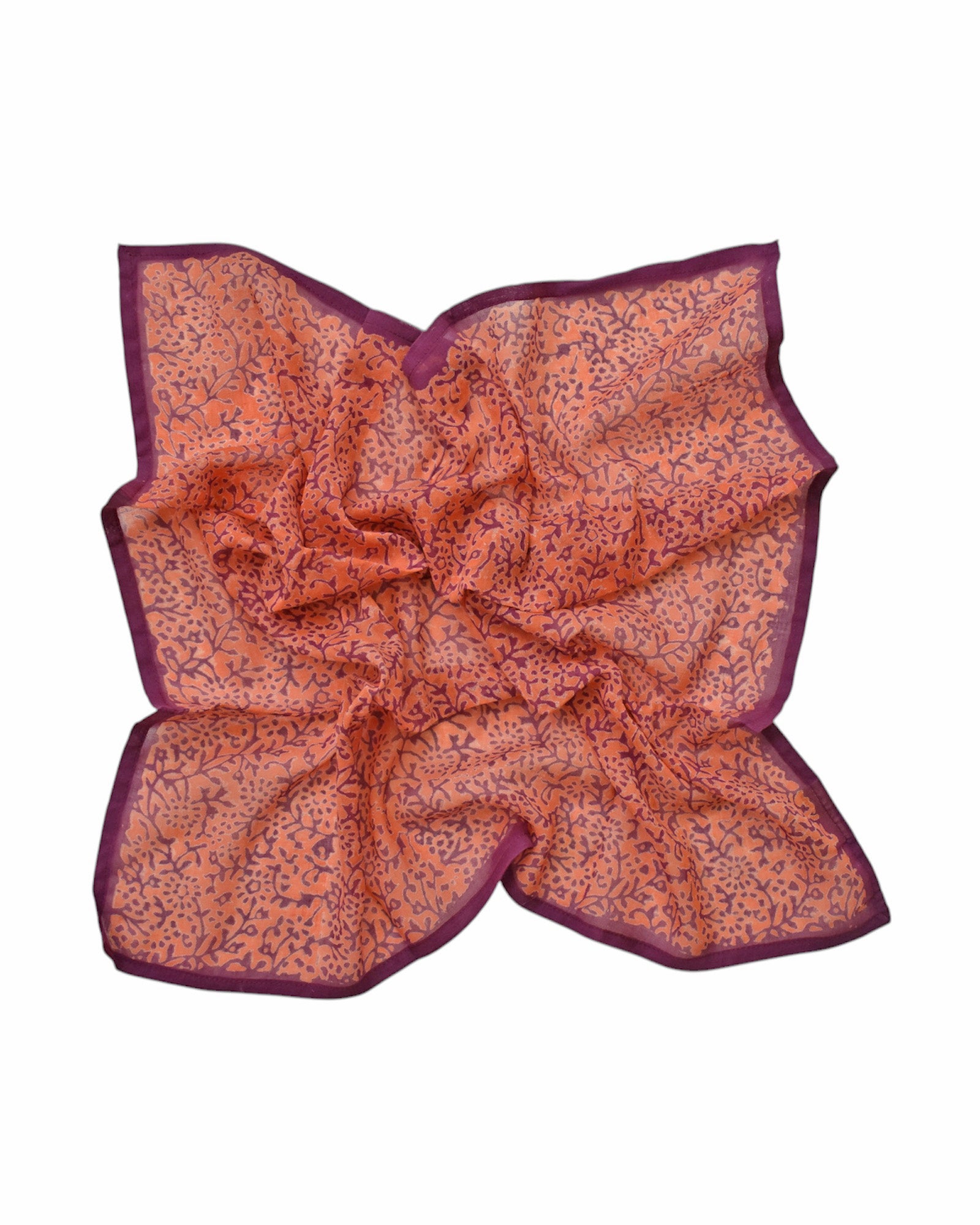 Block printed Amber bandana, laid flat scrunched up. Bandana has an all over floral print.
