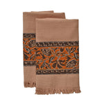 Block printed Cocoa khadi hand towels, folded and laid flat. Towels have a floral border print.