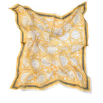 Tate yellow block printed floral bandana laid flat against a white background