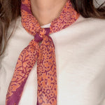 Woman wearing block printed Amber orange and purple bandana around the neck