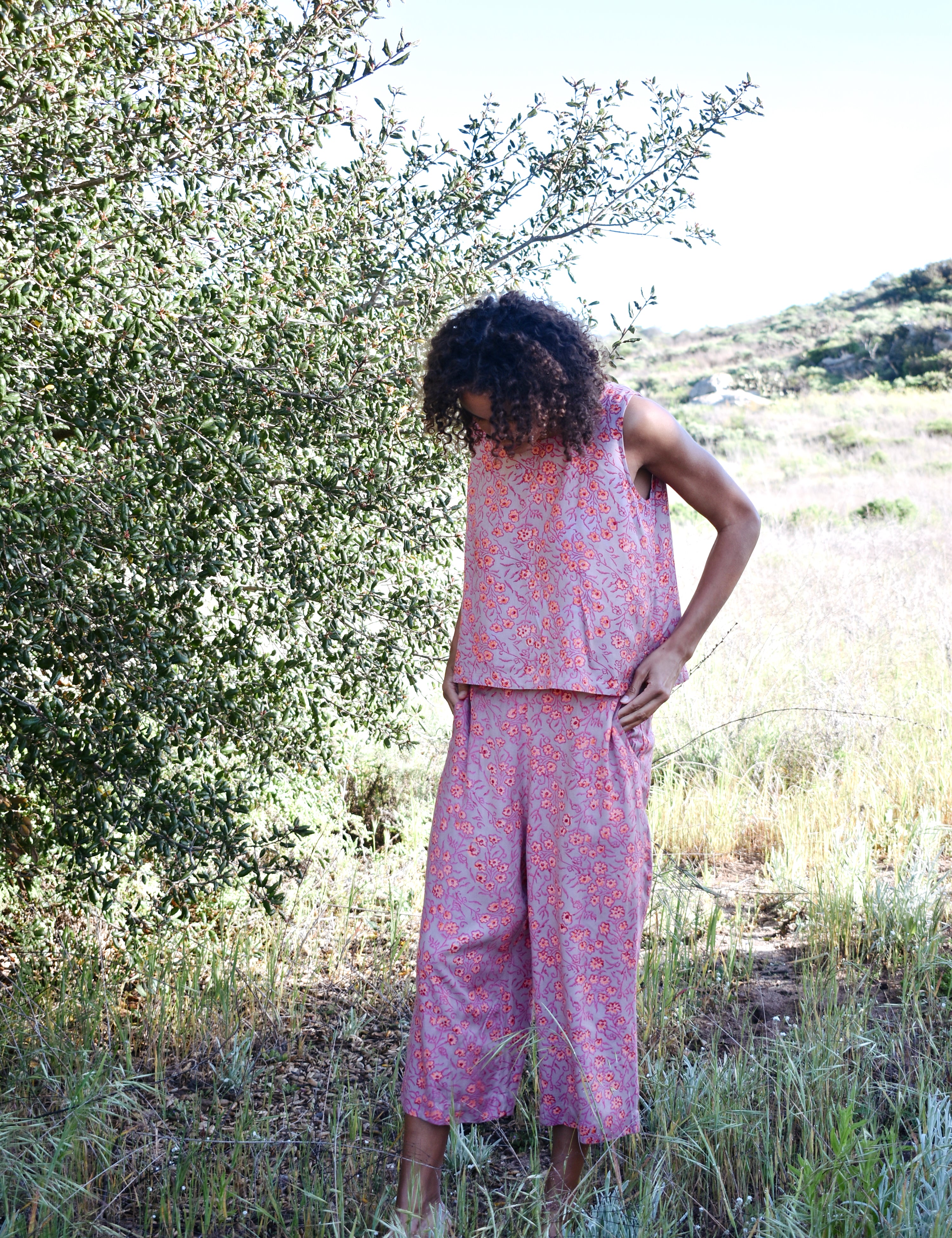 Woman wearing Birkin Set, standing outside with trees in the background