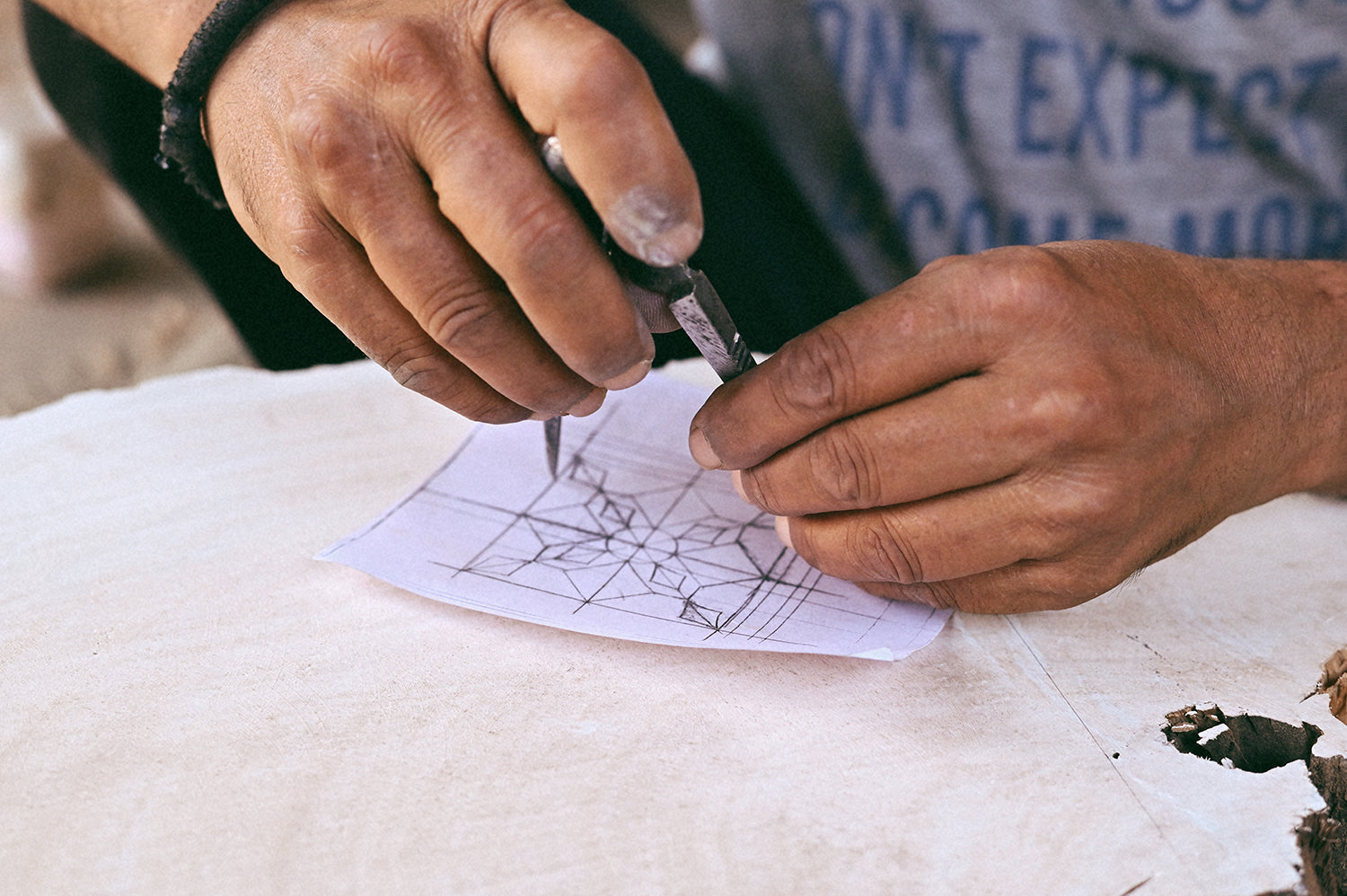 Artist tracing design onto wooden block