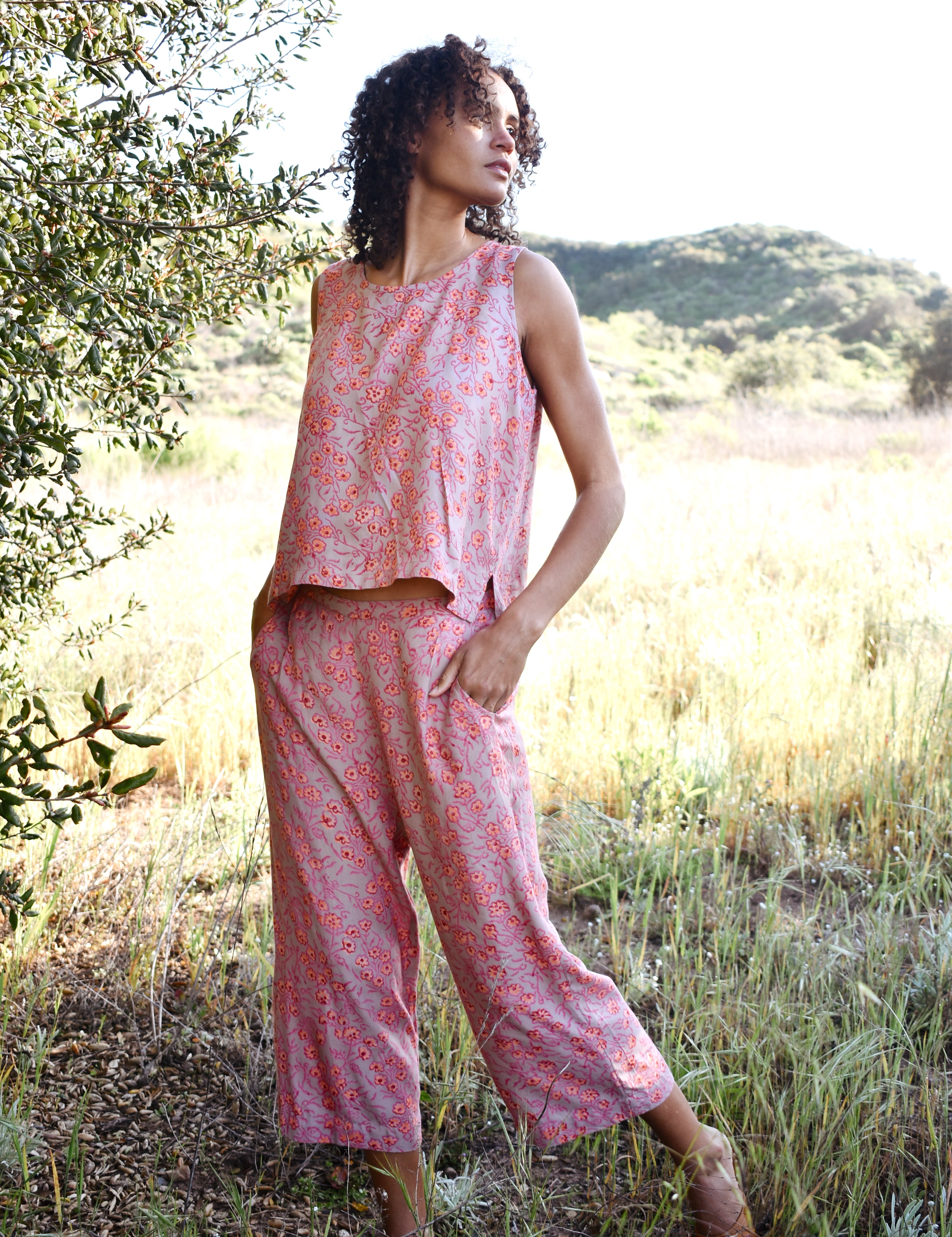 Woman wearing Birkin Set, standing outside with trees in the background