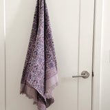 Purple floral-patterned towel hanging on a white door