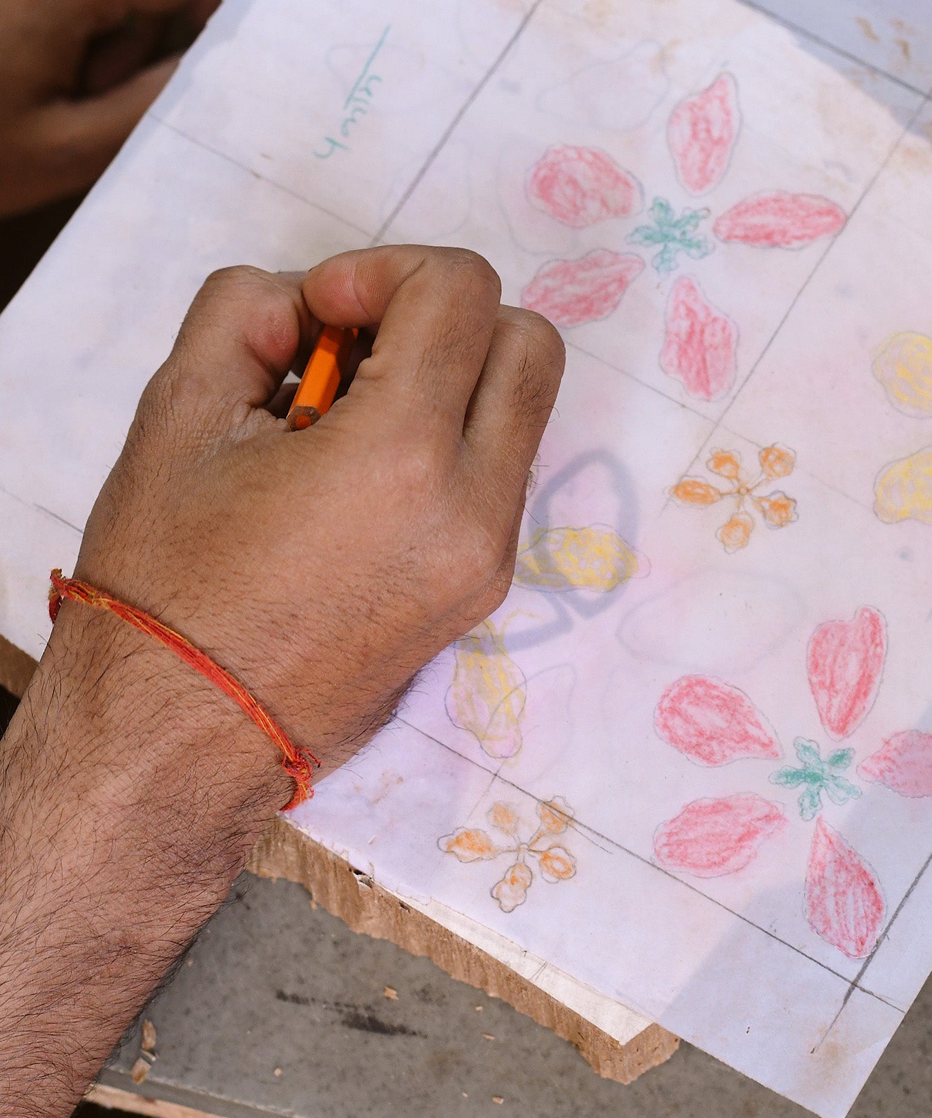 Artist drawing out flowers on transparent paper