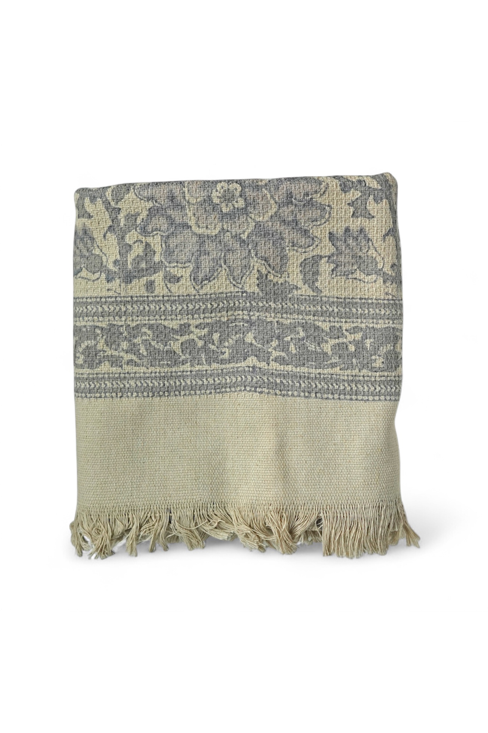 Grey bath towel with floral pattern and fringe on a white background
