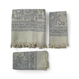 Set of three patterned towels with fringes on a white background