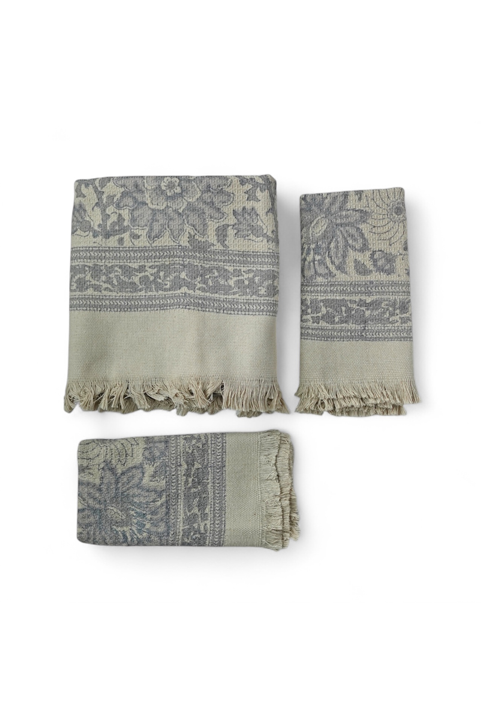 Set of three patterned towels with fringes on a white background