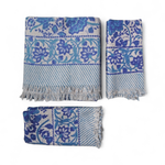 Set of three blue and white patterned towels with fringes on a white background