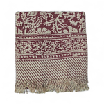 Red floral printed bath towels with intricate pattern and fringes on a white background