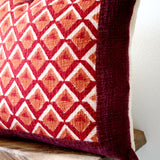 Pitaya block print pillow on a stool against white, angled