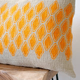Sol Block Print Pillow on a stool against white, angled