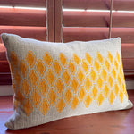 Sol Block Print Pillow on a wooden table, angled