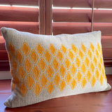 Sol Block Print Pillow on a wooden table, angled