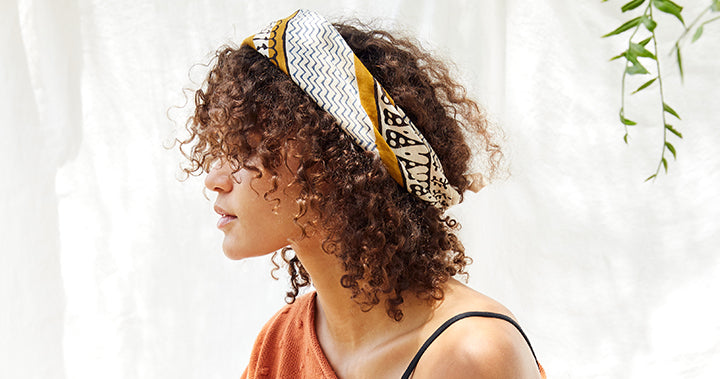 Model wearing a bandana tied as a headband in her hair