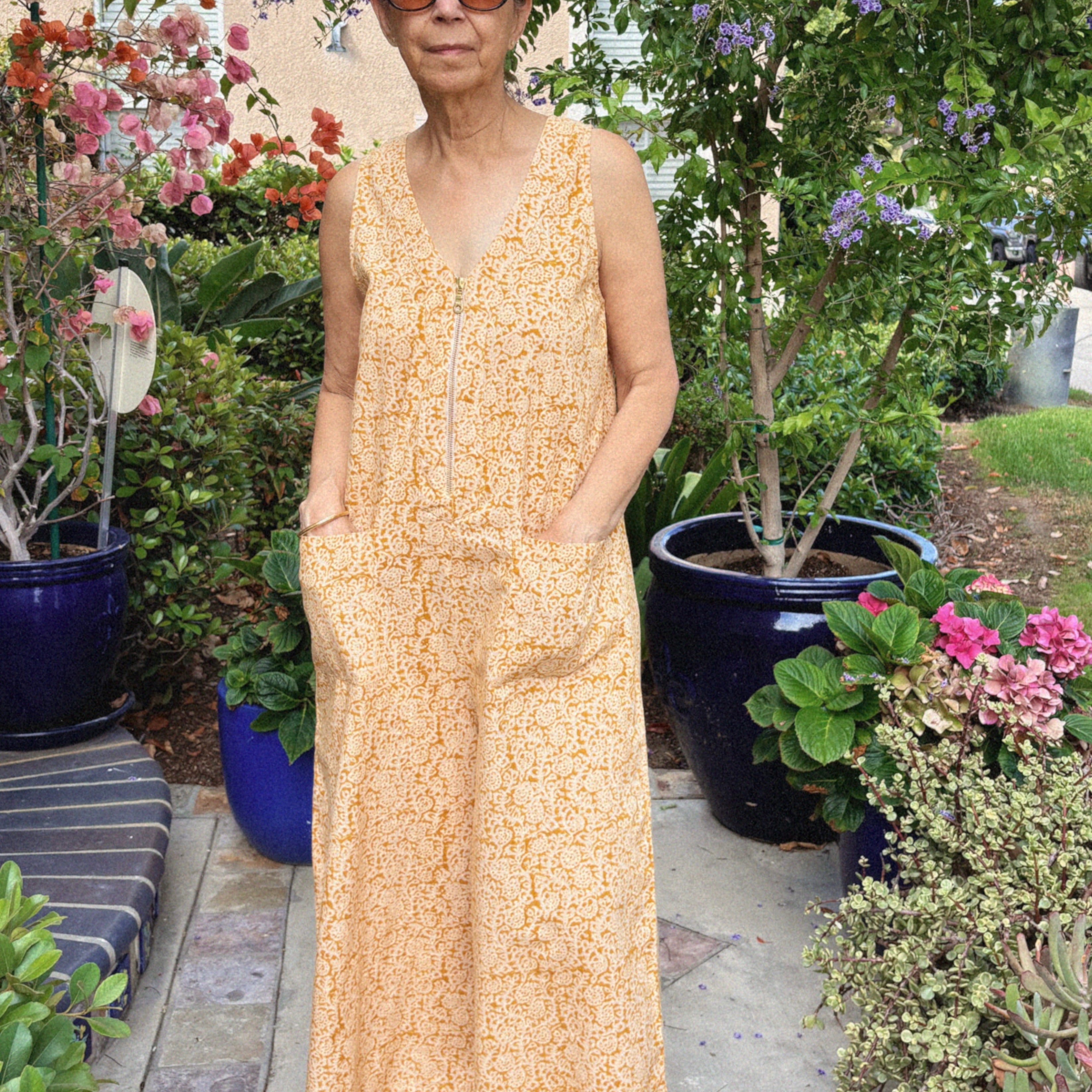 Mother's Day Gift Guide, Woman wearing a sleeveless yellow floral jumpsuit