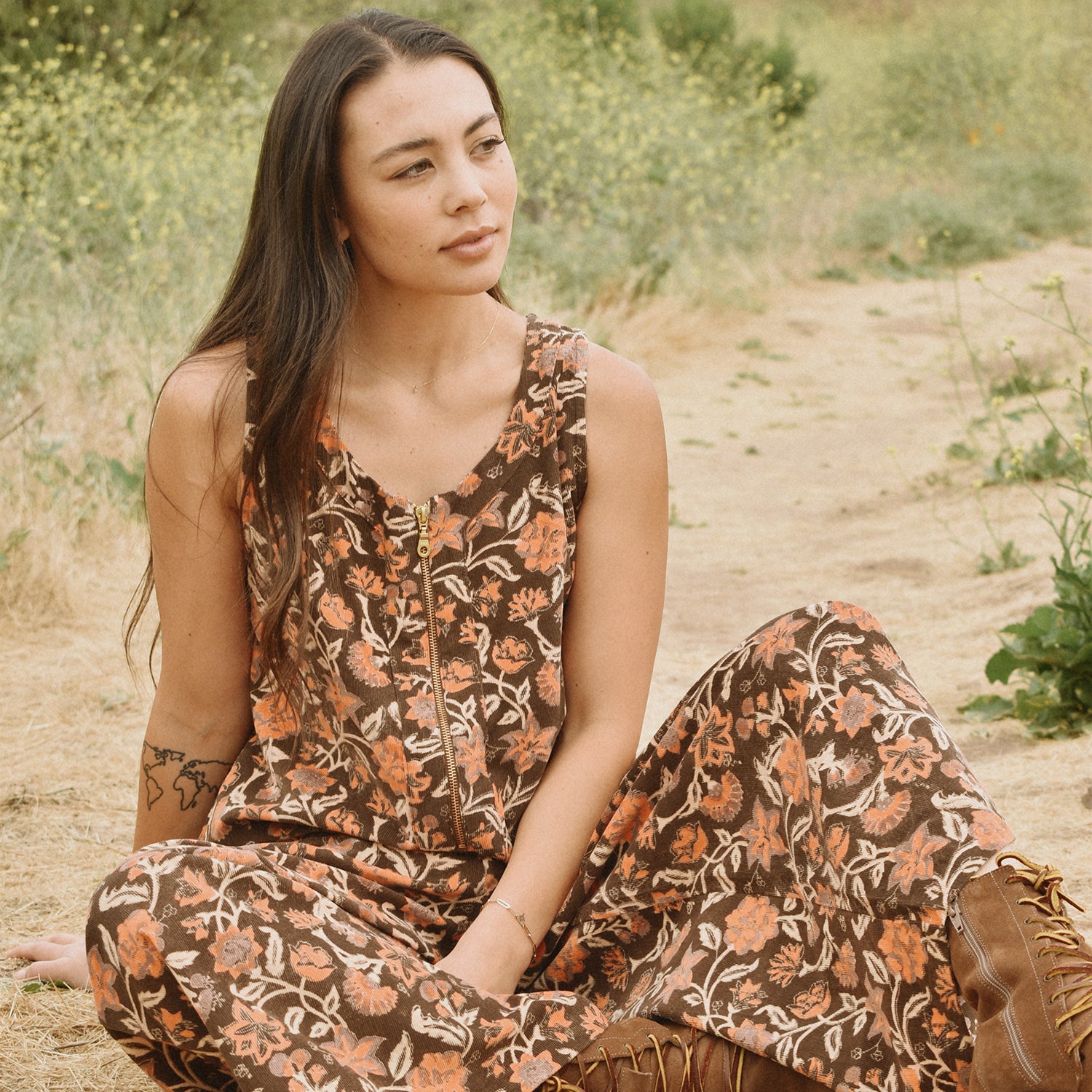 Woman wearing block printed, floral printed Corduroy Jumpsuit, sitting in nature