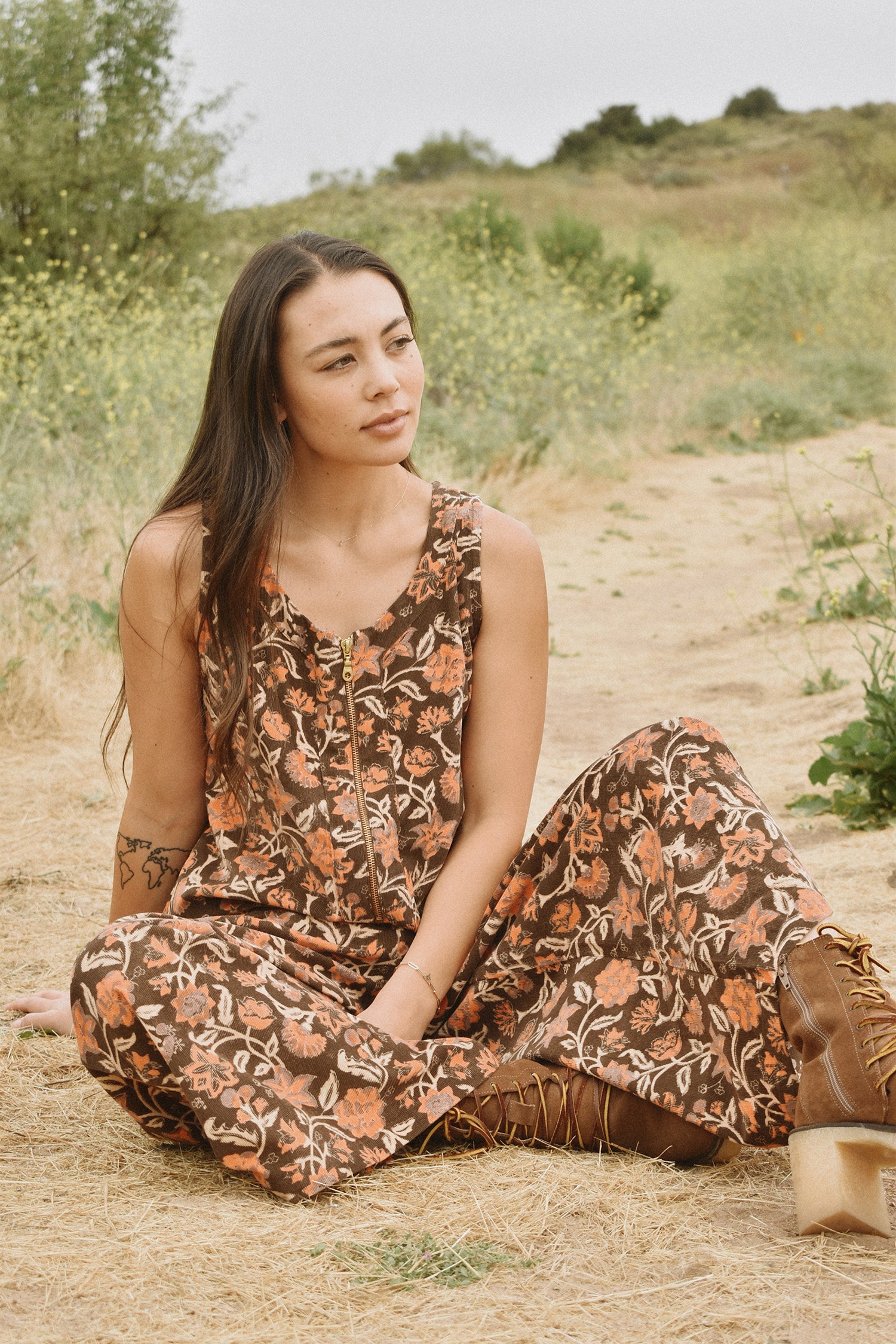 Woman wearing block printed, floral printed Corduroy Jumpsuit, sitting in nature