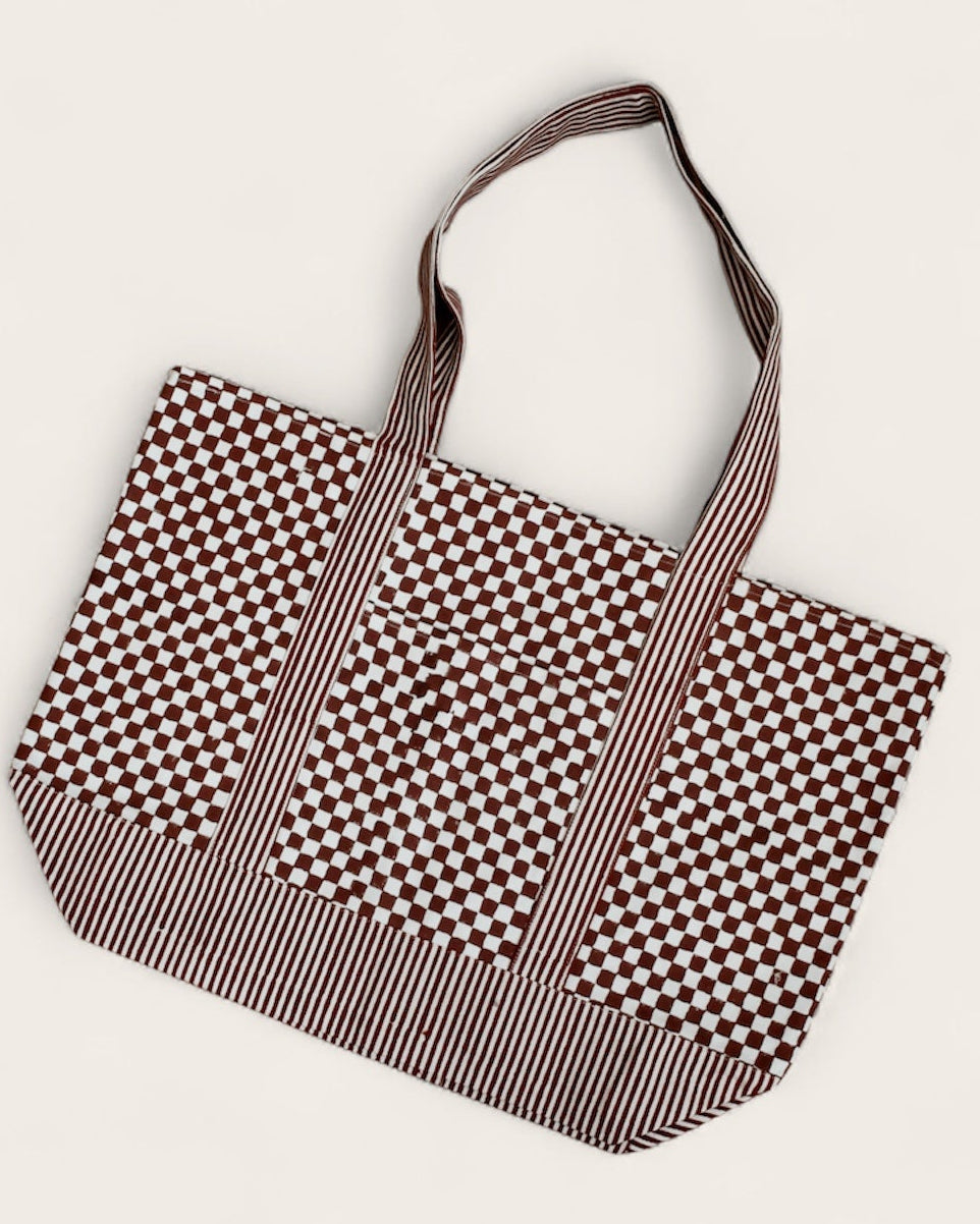 Block printed checkered and striped canvas tote bag laid flat
