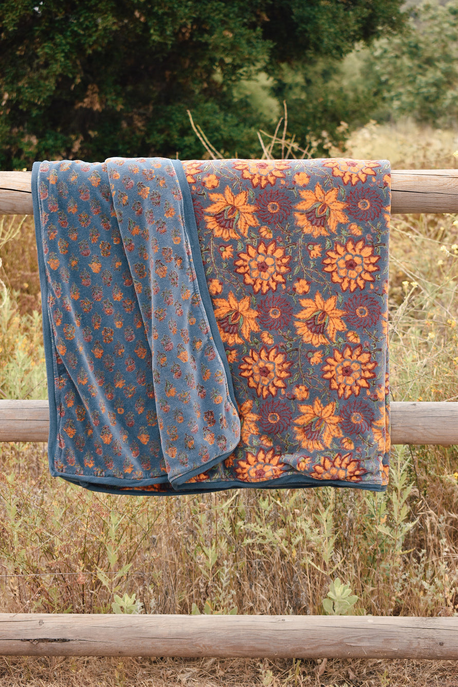 Model in tan/rust floral printed sleeveless jumpsuit standing out side on a hill