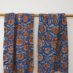 Two Adria block printed khadi cotton hand towels hanging on a gold bathroom rod