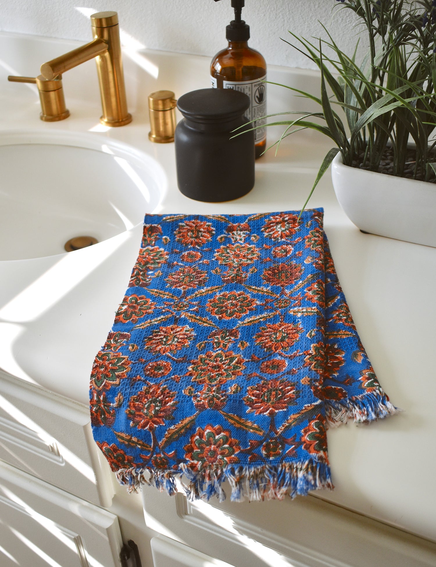 One Adria block printed hand towel folded and placed on a white bathroom counter