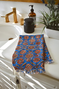 One Adria block printed hand towel folded and placed on a white bathroom counter
