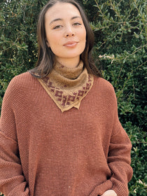 Floral printed bandana tied around the neck, styled with an orange brown sweater