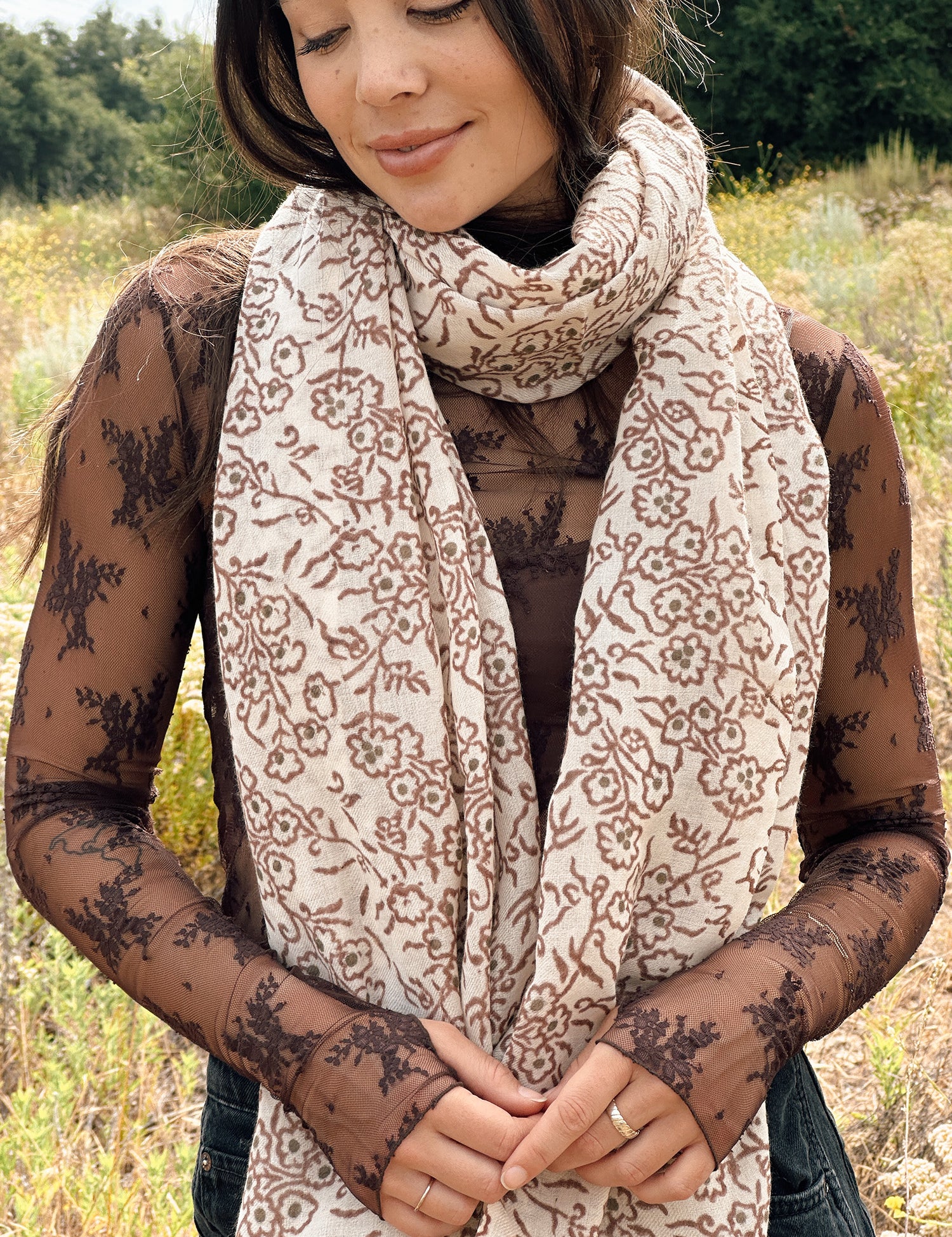 Block printed floral printed chunky wool scarf wrapped around neck, styled with sheer brown long sleeve