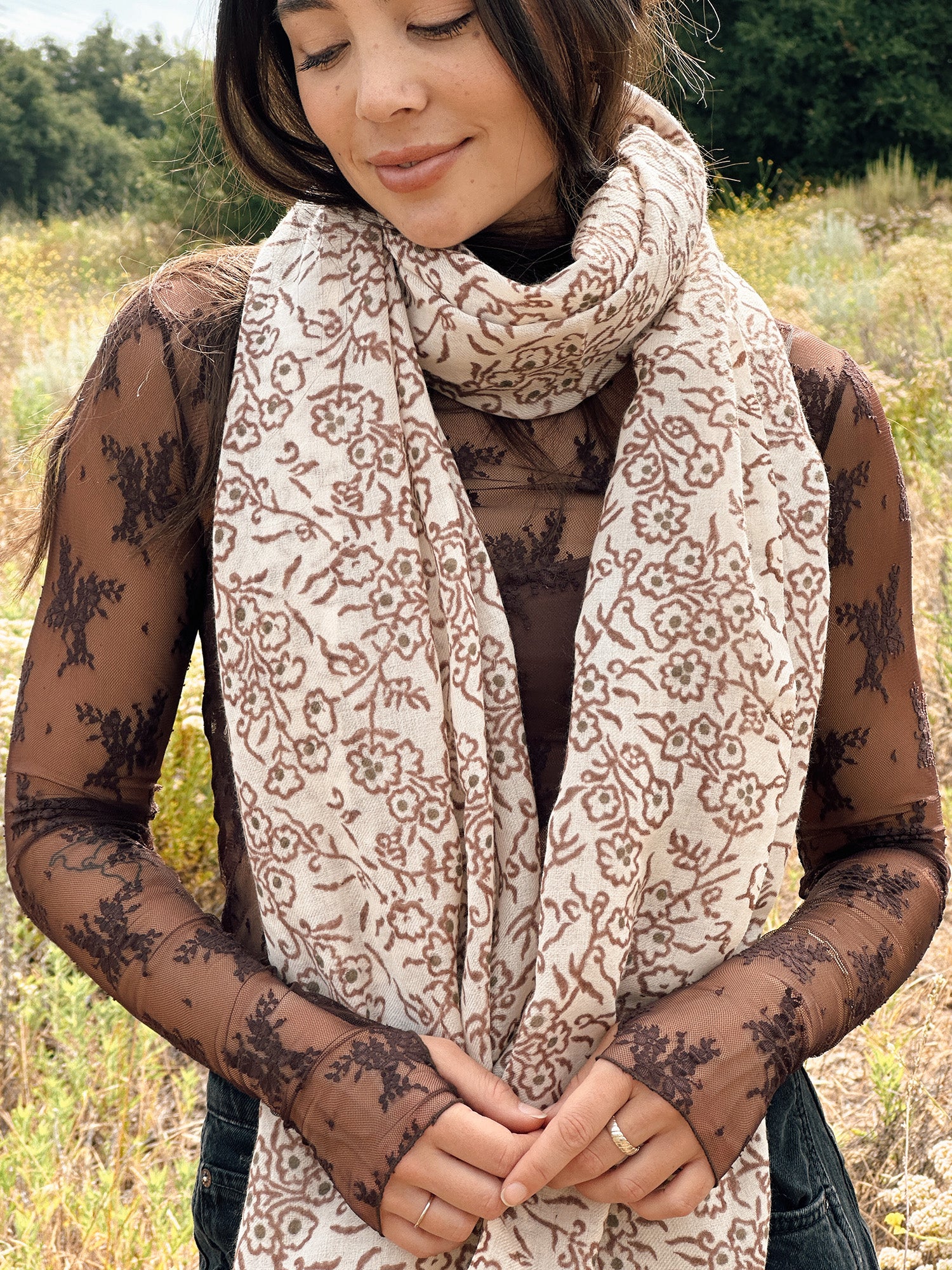 Block printed floral printed chunky wool scarf wrapped around neck, styled with sheer brown long sleeve