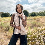 Block printed floral printed chunky wool scarf wrapped around neck, styled with sheer brown long sleeve and black denim jeans