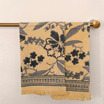 Set of two Bluebell hand block printed Khadi cotton hand towels hanging side-by-side on a brass towel rod featuring slate blue floral vines on a butter-cream background