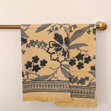 Set of two Bluebell hand block printed Khadi cotton hand towels hanging side-by-side on a brass towel rod featuring slate blue floral vines on a butter-cream background