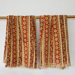 Two Camila block printed khadi cotton hand towels hanging on a gold bathroom rod