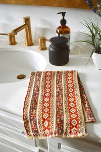 One Camila block printed hand towel folded and placed on a white bathroom counter