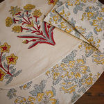 Floral-patterned placemats and napkins on a wooden surface