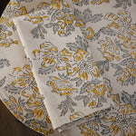 Floral printed placemat with matching table napkin on top, on a wooden surface
