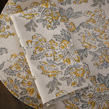 Floral printed placemat with matching table napkin on top, on a wooden surface