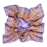 Chamomile bandana scarf laid flat on white background. Scarf has a lavender background with a green floral border print, and yellow flowers towards the center.