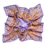 Chamomile bandana scarf laid flat on white background. Scarf has a lavender background with a green floral border print, and yellow flowers towards the center.