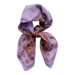 Chamomile bandana scarf tied on white background. Scarf has a lavender background with a green floral border print, and yellow flowers towards the center.