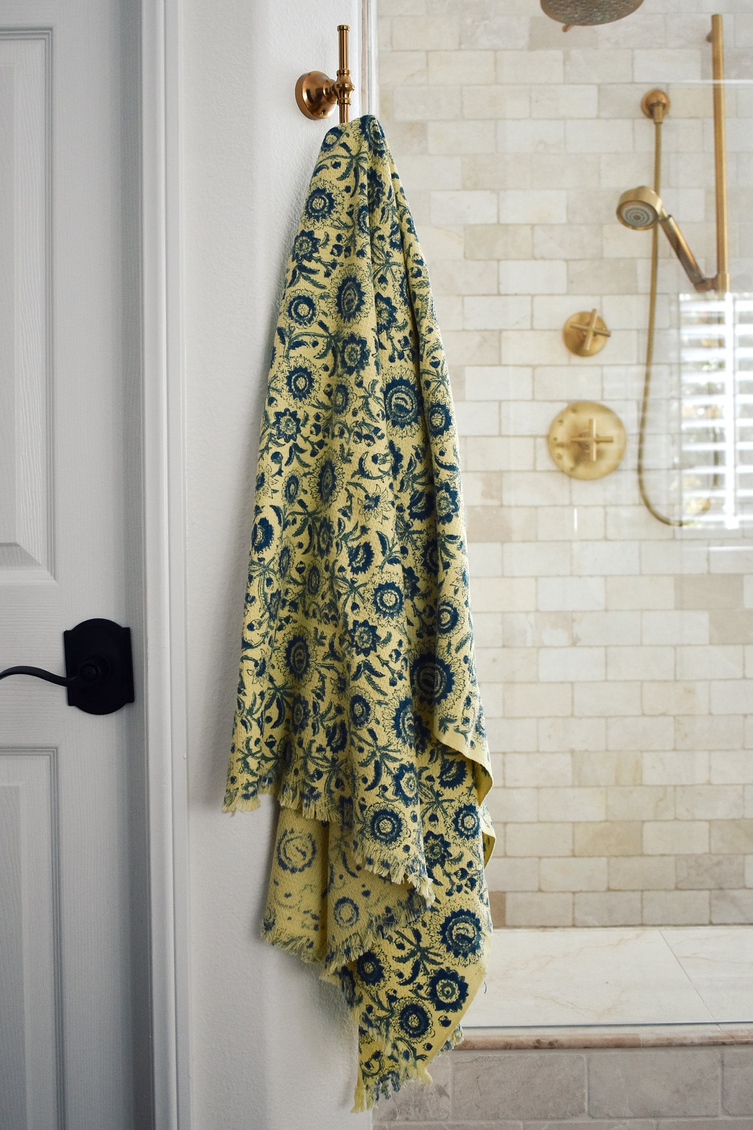 Block printed floral print waffle weave bath towel hanging on a hook