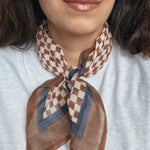 Person wearing a brown and beige checkered scarf