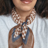 Person wearing a brown and beige checkered scarf